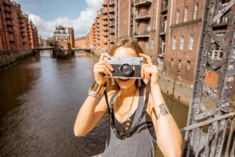 junge Frau mit Kamera in der Hafencity Hamburg